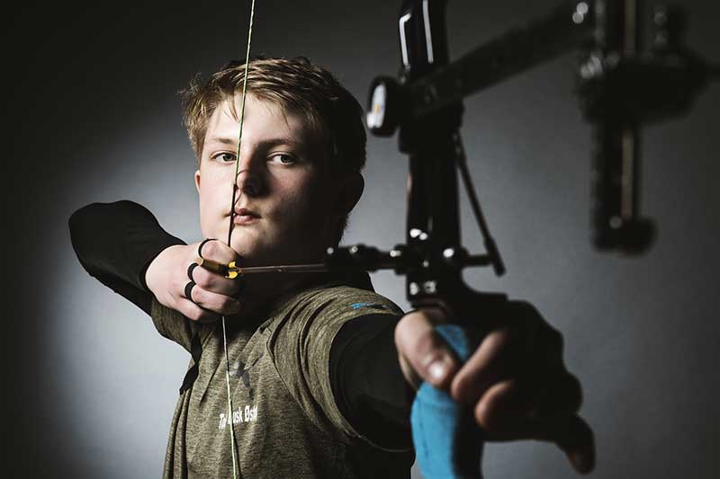 boy aiming used bow